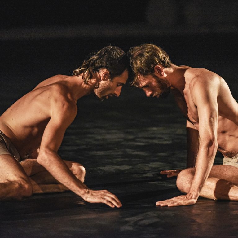 2 dancers sitting on the floor with their heads touching
