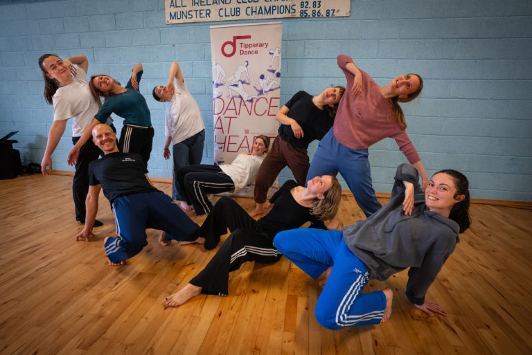 A group shot of various dancers posing in front of Tipperary Dance Festival pullup poster