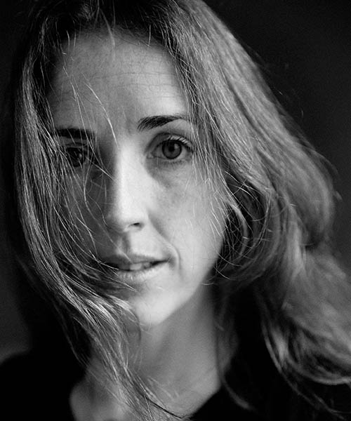 A headshot of Laura Murphy on a dark background